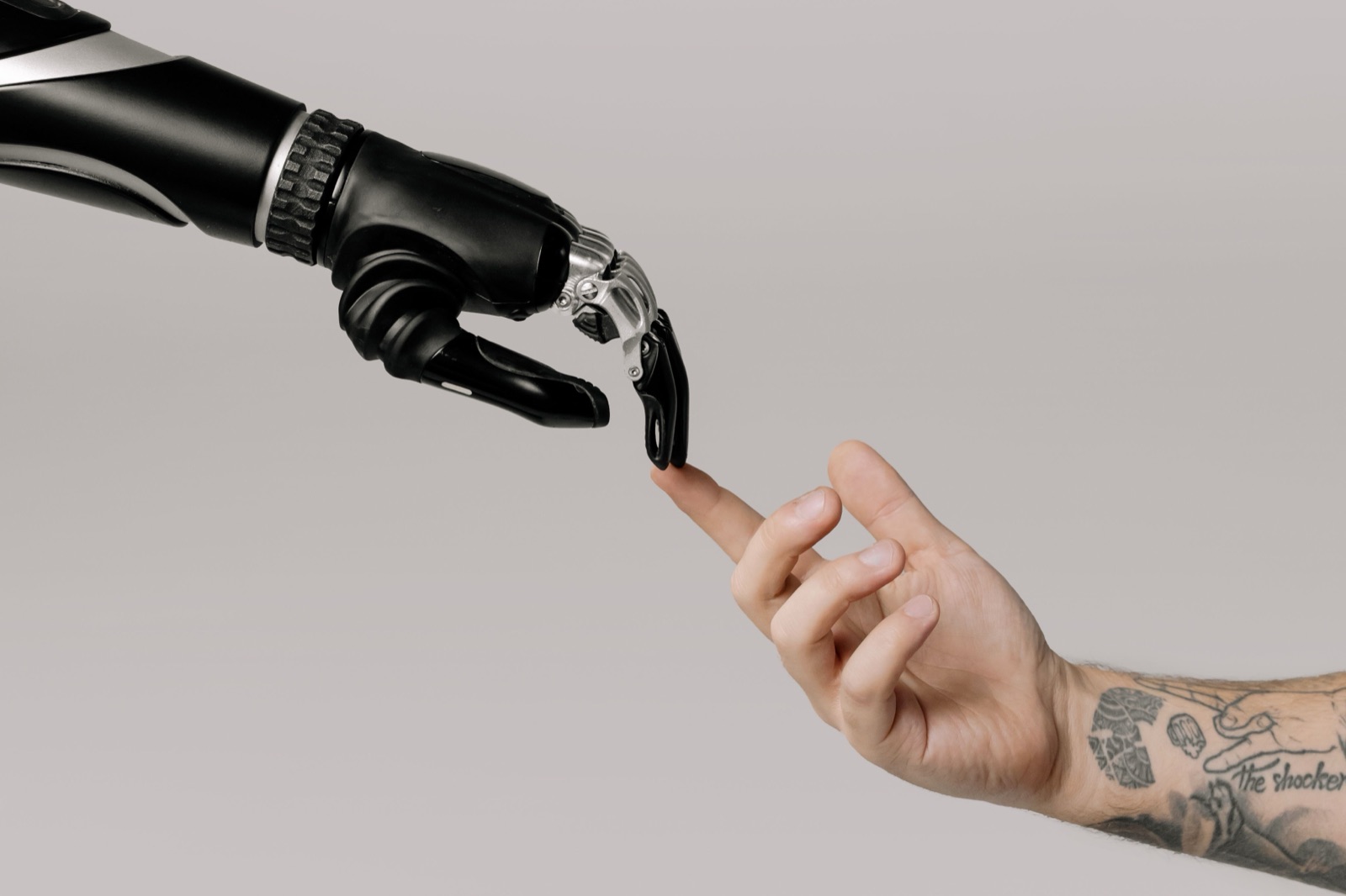 A human hand reaching toward a robotic hand, representing human-robot collaboration